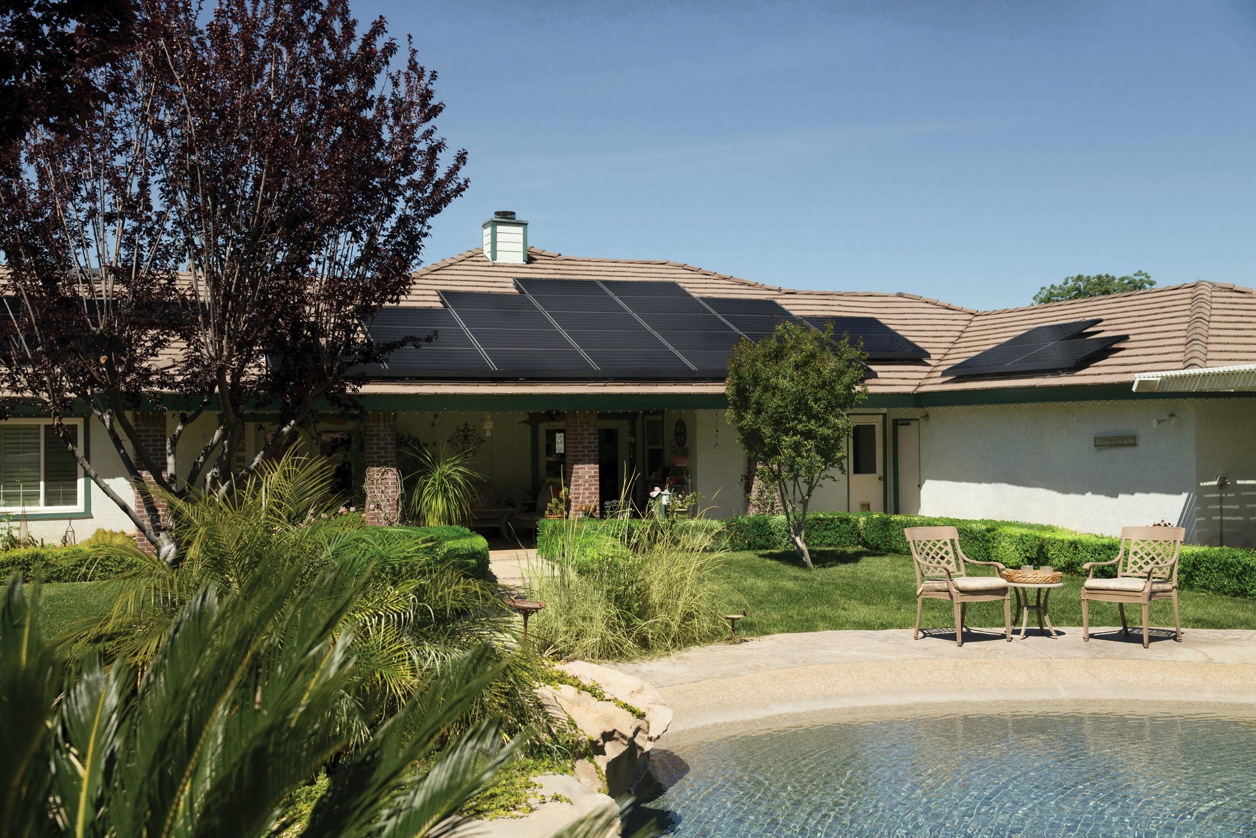 fotovoltaické panely na střeše rodinného domu s bazénem